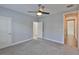 Bright bedroom featuring a ceiling fan and neutral gray carpet, with white doors to adjoining rooms at 6619 S Manhattan Ave # 1, Tampa, FL 33616