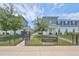 Camellia Square Townhomes with well-manicured lawns are framed by wrought iron fences and lush trees under a bright sky at 6619 S Manhattan Ave # 1, Tampa, FL 33616