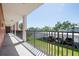 Balcony view featuring a metal railing, grass, parking lot, and landscape views under a bright blue sky at 6960 20Th N Ave # 203B, St Petersburg, FL 33710