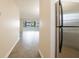 Hallway leading to living room featuring modern flooring and stainless steel refrigerator at 6960 20Th N Ave # 203B, St Petersburg, FL 33710