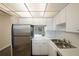 Bright kitchen featuring white cabinets, stainless steel refrigerator, and double basin sink at 6960 20Th N Ave # 203B, St Petersburg, FL 33710