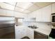 Compact kitchen featuring white countertops, stainless steel appliances, and ample cabinetry at 6960 20Th N Ave # 203B, St Petersburg, FL 33710