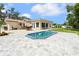 Backyard showcasing the pool, brick patio, metal roof, grass and covered seating area at 708 Westwood Cir, Brandon, FL 33511