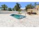 Backyard featuring a metal roof, seating, pool and stone paved patio in the sunshine at 708 Westwood Cir, Brandon, FL 33511