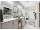 Bright bathroom featuring double vanities, a glass-enclosed shower, and marble-look tile at 708 Westwood Cir, Brandon, FL 33511