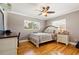 Cozy bedroom featuring hardwood floors, a ceiling fan, and natural light from two windows at 708 Westwood Cir, Brandon, FL 33511