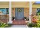 Close-up of a beautiful front door with a wreath, flanked by decorative columns and vibrant plants at 708 Westwood Cir, Brandon, FL 33511