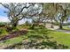 Charming home features a lush front yard with mature trees, plants, and a well-manicured lawn at 708 Westwood Cir, Brandon, FL 33511
