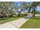 Charming home featuring a long driveway, lush lawn, and mature trees, providing a welcoming entrance at 708 Westwood Cir, Brandon, FL 33511