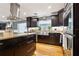 Modern kitchen with stainless steel appliances, dark cabinets, a large island, and hardwood floors at 708 Westwood Cir, Brandon, FL 33511