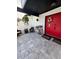Covered front porch with seating area, decorative plants, and a bright red front door at 7312 Nova Cir, Tampa, FL 33634