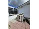 Side view of a house with AC unit on a brick platform adjacent to a screened-in patio and swimming pool at 7834 Treasure Pointe Dr, Port Richey, FL 34668