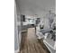 Open-concept kitchen featuring modern gray cabinetry, stainless steel appliances, and a dining area with a chandelier at 7834 Treasure Pointe Dr, Port Richey, FL 34668