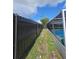 Poolside view showing black metal fence and screened-in pool enclosure at 7834 Treasure Pointe Dr, Port Richey, FL 34668