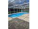 Inviting private pool surrounded by a screened enclosure and a paver patio, perfect for relaxation at 7834 Treasure Pointe Dr, Port Richey, FL 34668