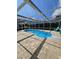 Inviting screened-in pool and outdoor patio with brick pavers, with stylish outdoor furniture at 7834 Treasure Pointe Dr, Port Richey, FL 34668