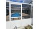 Screened-in pool area with a turquoise chair and a refreshing blue pool at 7834 Treasure Pointe Dr, Port Richey, FL 34668