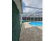 Enclosed pool area featuring privacy hedges, cool deck, and stylish outdoor furniture at 7834 Treasure Pointe Dr, Port Richey, FL 34668