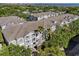 An aerial view of a gray condominium building with white balconies, surrounded by lush greenery and overlooking the water at 800 S Dakota Ave # 337, Tampa, FL 33606