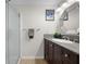 Bathroom featuring a glass door shower, granite countertop sink, and decorative art at 800 S Dakota Ave # 337, Tampa, FL 33606