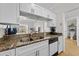 Bright kitchen with granite countertops, stainless steel sink, dishwasher, and white cabinetry at 800 S Dakota Ave # 337, Tampa, FL 33606