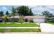 Beautiful single-story home with a well-maintained lawn, mature palms, and a two-car garage at 8060 Canterbury Cir, Seminole, FL 33777