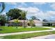 Inviting single-Gathering home featuring lush green lawn, tropical palms, and a convenient two-car garage at 8060 Canterbury Cir, Seminole, FL 33777