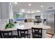 Well-lit kitchen featuring white cabinetry, stainless steel appliances, and a breakfast bar with seating at 8060 Canterbury Cir, Seminole, FL 33777