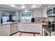 Modern kitchen with white cabinets, stainless steel appliances, and a view of the outdoors at 8060 Canterbury Cir, Seminole, FL 33777