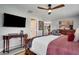 A spacious main bedroom with a ceiling fan, mounted TV, wood furniture, and stylish decor at 8060 Canterbury Cir, Seminole, FL 33777