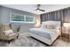 A comfortable main bedroom with a ceiling fan, gray accents, and a large window providing natural light at 8060 Canterbury Cir, Seminole, FL 33777