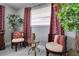 A cozy sitting area, featuring comfortable chairs, a glass table, leafy green plants, and stylish decor at 8060 Canterbury Cir, Seminole, FL 33777