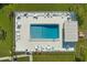 Aerial view of community pool with tables, chairs and lounges surrounded by fence and green space at 9314 Alta Sol Way, New Port Richey, FL 34655