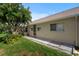 Home's backyard with well-maintained grass, a lush tree, and a covered patio area at 9314 Alta Sol Way, New Port Richey, FL 34655