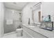 Bright bathroom featuring marble walls, a glass-enclosed shower, and a gray granite countertop at 9314 Alta Sol Way, New Port Richey, FL 34655