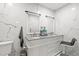 Modern bathroom featuring a double sink vanity with gray granite countertop and marble tile walls at 9314 Alta Sol Way, New Port Richey, FL 34655