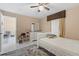 Bright bedroom with a ceiling fan and white tile floor, featuring a gray rug and a built-in shelving unit for storage at 9314 Alta Sol Way, New Port Richey, FL 34655