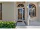 The beautiful front entrance features sidelight windows, tile flooring, and manicured landscaping at 9314 Alta Sol Way, New Port Richey, FL 34655