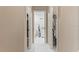 Hallway view showcasing access to a bathroom with white marble tile and two walk-in closets at 9314 Alta Sol Way, New Port Richey, FL 34655