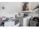 Laundry room with white washing machine, dryer, sink, and water heater, ready for all your laundry needs at 9314 Alta Sol Way, New Port Richey, FL 34655