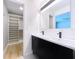 Bathroom featuring a double sink vanity, large mirror, and a walk-in closet at 9580 130Th Ave, Largo, FL 33773