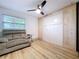 Cozy bedroom with murphy bed, ceiling fan, laminate floors, and comfortable gray recliner chair at 9580 130Th Ave, Largo, FL 33773