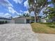 Charming single-story home with a well-maintained lawn and a patterned brick driveway on a sunny day at 9580 130Th Ave, Largo, FL 33773