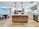 Open kitchen with white cabinets, an island with light wood cabinets, and stainless steel appliances at 9580 130Th Ave, Largo, FL 33773