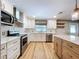 A modern kitchen featuring white cabinets, stainless steel appliances, and a stylish backsplash at 9580 130Th Ave, Largo, FL 33773