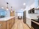 Well-lit kitchen with marble countertops, white upper cabinets, light wood lower cabinets and stainless appliances at 9580 130Th Ave, Largo, FL 33773