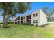 Property exterior featuring screened lanais, lush landscaping, and a beautiful mature tree at 9700 Starkey Rd # 312, Seminole, FL 33777