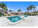 Community pool surrounded by lounge chairs and palm trees on a clear day at 9700 Starkey Rd # 312, Seminole, FL 33777