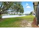 Beautiful backyard with lush green lawn and view of the peaceful lake, framed by a mature shade tree at 9721 Fredericksburg Rd, Tampa, FL 33635