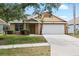 Charming single-story home with a well-manicured lawn, neutral paint, and an attached two-car garage at 9721 Fredericksburg Rd, Tampa, FL 33635